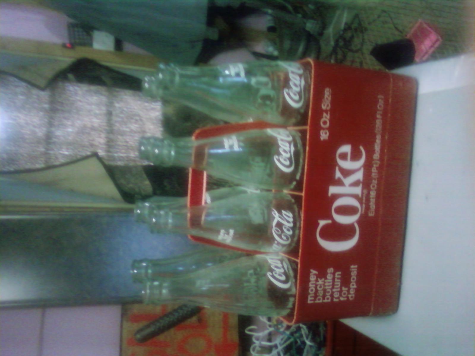 8- 16oz. coke bottles in a plastic carrying case
