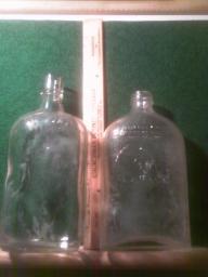 2 clear embossed liquor bottles